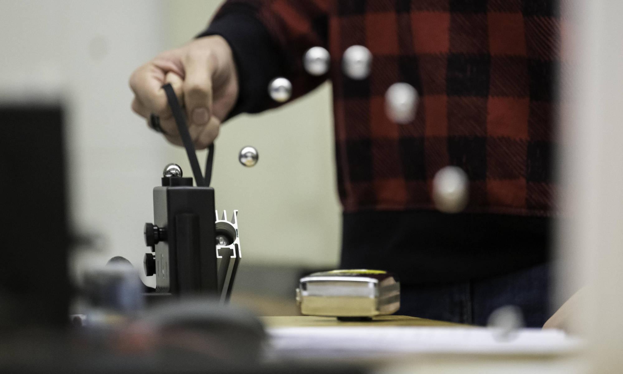 在机械工程课和实验中，一个金属球穿过弹簧发射装置的合成照片.